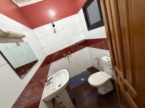 a small bathroom with a toilet and a sink at Abbe Residence in Bamako