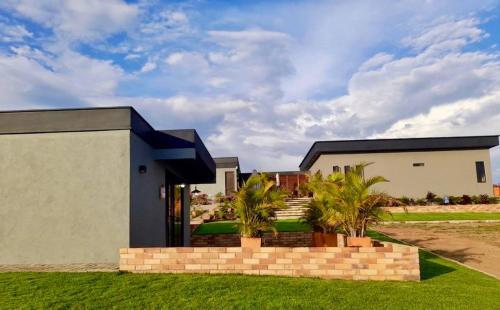 a home with a brick retaining wall and palm trees at LUZ DE LUNA mesa de los santos house in Los Santos