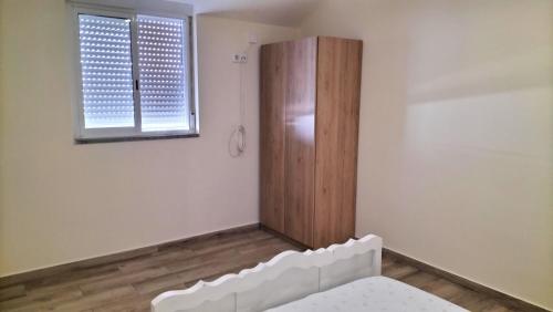 a room with a bed and a wooden cabinet at AL - Bino - T3 in Carregosa