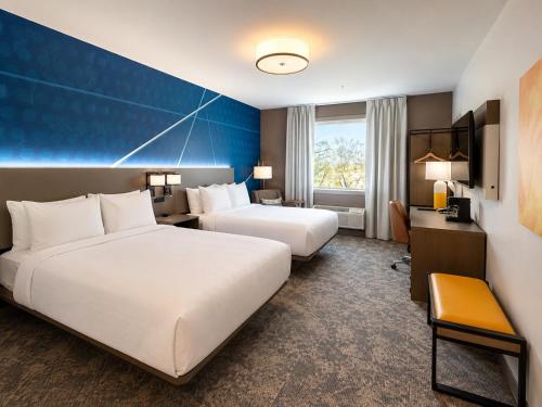 a hotel room with two beds and a desk at Comfort Inn & Suites in Penticton