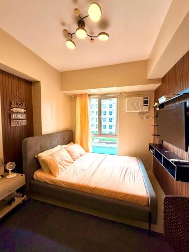 a bedroom with a bed and a window at Avida Condo Lux Studio Unit in Iloilo City