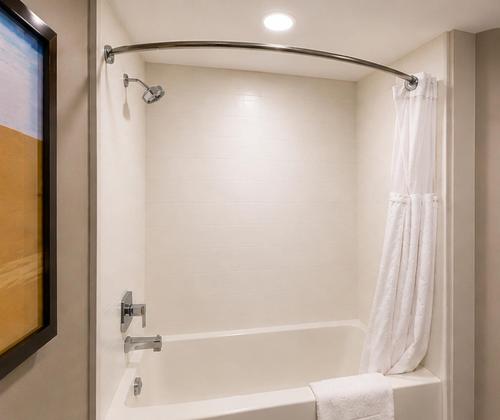 a bathroom with a bath tub with a shower curtain at Comfort Inn & Suites in Penticton