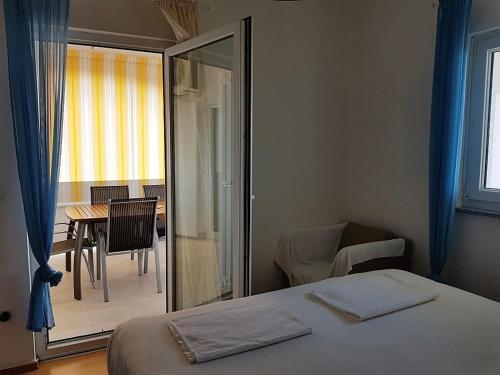 a bedroom with a bed and a table with chairs at Apartment Oasis - Novalja in Novalja