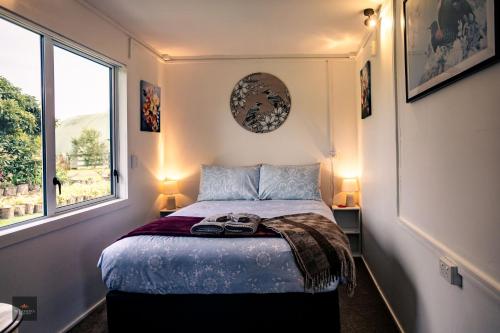 a bedroom with a bed with two lamps and a window at Oak Lodge in Taheke