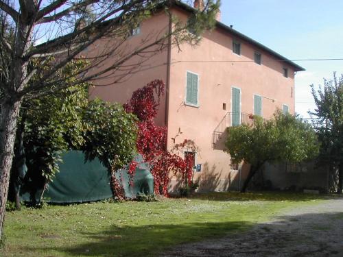 a large pink house with trees in front of it at Agriturismo Il Giardino in Sansepolcro