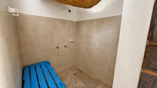a bathroom with a blue bench in a shower at El Árbol de la Vida in Bacalar