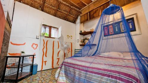 a bedroom with a bed with a canopy at El Árbol de la Vida in Bacalar
