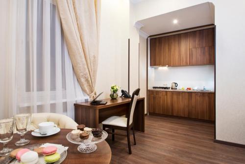 a living room with a table and a kitchen at BonApart Hotel by UHM in Kyiv