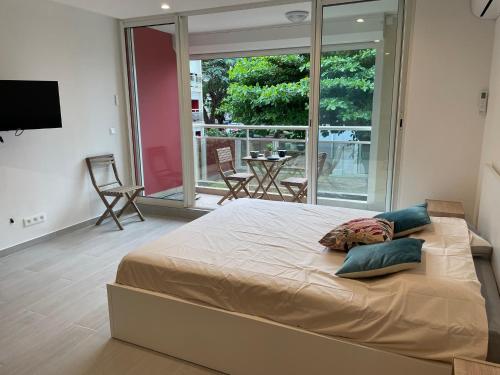 a large bed in a bedroom with a balcony at Studio Marigot Fort Louis in Marigot