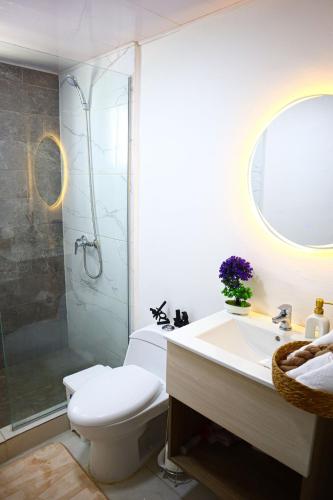 a bathroom with a shower and a toilet and a sink at Your Private Patio Oasis Spa Pool Lounge 2BR in Santiago de los Caballeros