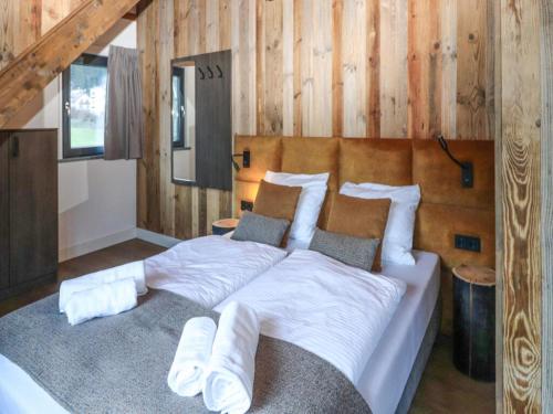 a large bed in a room with wooden walls at Bergblick am Afritzer See in Afritz