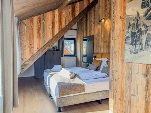 a bedroom with a bed in a room with wooden walls at Alpenchalet am See in Afritz
