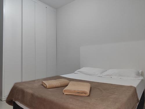 a bed with two towels sitting on top of it at apartment work centro in Ubá