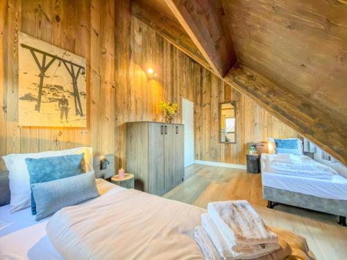two beds in a room with wooden walls at Alpenchalet Kärntnerglück in Afritz