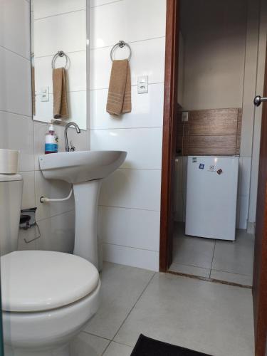 a bathroom with a white toilet and a sink at apartment work centro in Ubá