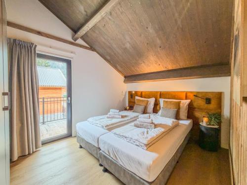 a bedroom with a large bed and a large window at Verditzblick in Afritz