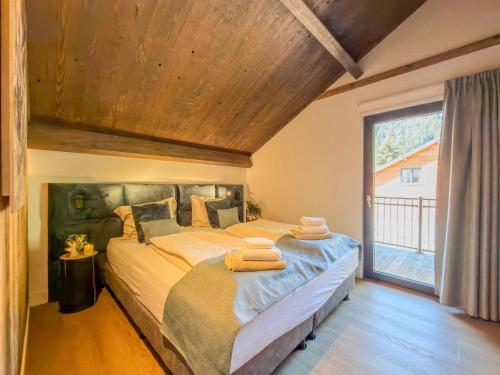 a bedroom with a large bed with towels on it at Alpensehnsucht in Afritz