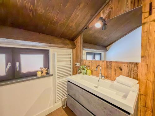 a bathroom with a large sink and wooden walls at Seechalet Afritz in Afritz