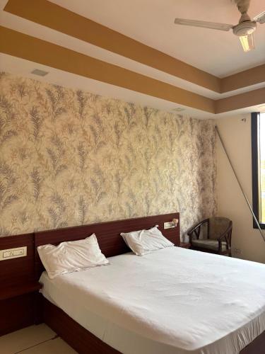 a bedroom with a large bed with white sheets at 9 orchid Parbhat royal in Gobindgarh