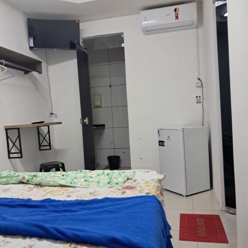 a room with a bed and a refrigerator at Central in Juazeiro do Norte