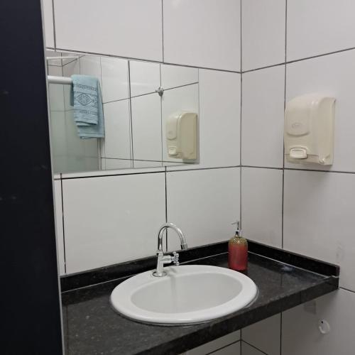 a bathroom with a sink and a mirror at Central in Juazeiro do Norte