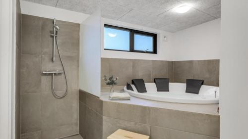a bathroom with a tub and a shower at Villavilla 581 - Gjerrild, Østjylland in Grenå