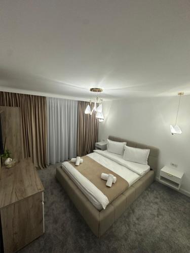 a bedroom with a large bed with two towels on it at Casa DAIANA in Moisei