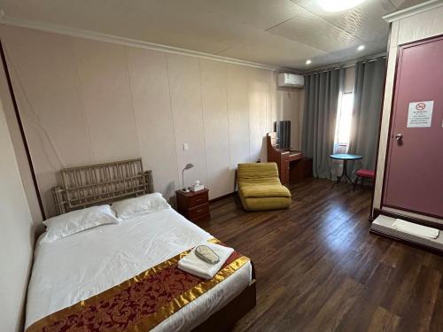 a hotel room with a bed and a chair at CHINA STAR HOTEL in Kolonia