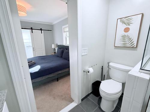 a bathroom with a toilet and a bed at Glam Parkville Experience! in Parkville