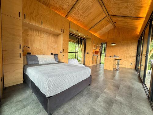 a bedroom with a bed and a table in it at Glamping Bosque de helechos, privacidad y cercanía in Manizales