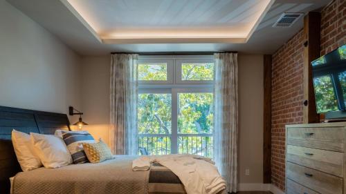 a bedroom with a bed and a large window at Paso Park Suites by AvantStay in Paso Robles