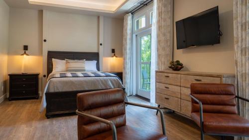 a bedroom with a bed and a tv on the wall at Paso Park Suites by AvantStay in Paso Robles