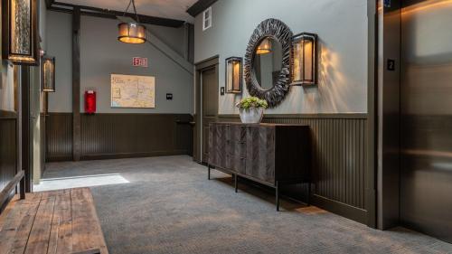 a hallway with a mirror on the wall and a table at Paso Park Suites by AvantStay in Paso Robles