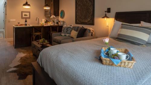 a bedroom with a bed with a basket of cups and a couch at Paso Park Suites by AvantStay in Paso Robles