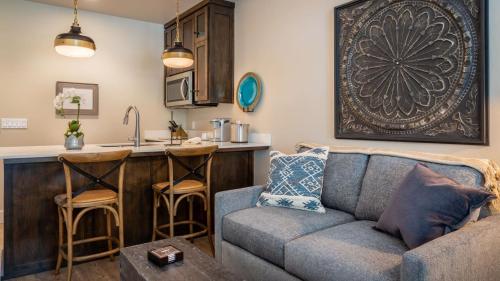 a living room with a couch and a kitchen at Paso Park Suites by AvantStay in Paso Robles