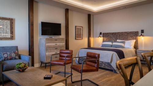 a bedroom with a bed and a tv and a couch at Paso Park Suites by AvantStay in Paso Robles