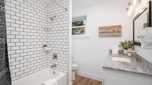 a bathroom with a tub and a toilet and a sink at 8 Mile House by AvantStay in Santa Margarita