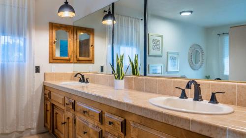 a bathroom with two sinks and a large mirror at Na Hoku Ranch by AvantStay in Atascadero