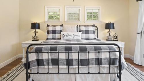 a bedroom with a black and white bed with pillows at 13th Street Retreat by AvantStay in Paso Robles