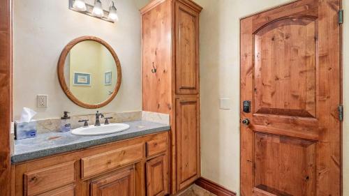 a bathroom with a sink and a mirror and a door at Vita Amorosa by AvantStay in Atascadero