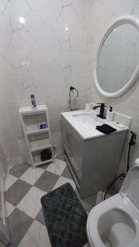 a white bathroom with a sink and a mirror at Tam-Toboyah in Conakry