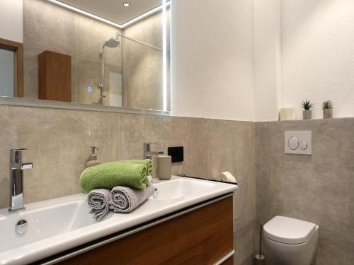 a bathroom with a green towel on a sink at Panoramic view apartment Kaunergrat in Kaunerberg