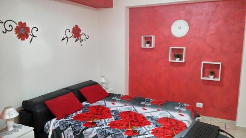 B&B Le Tre Gemme Junior في لينتيني: غرفة نوم بسرير بجدار احمر