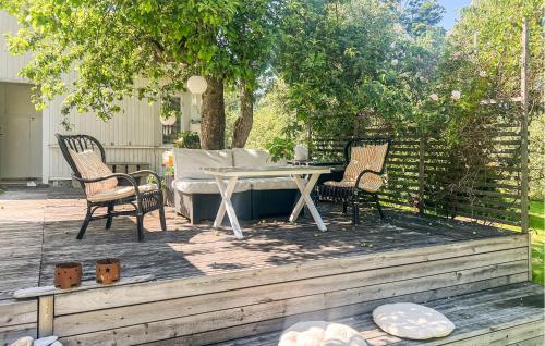 a patio with a table and chairs on a deck at 2 Bedroom Lovely Home In Ödeshög in Ödeshög