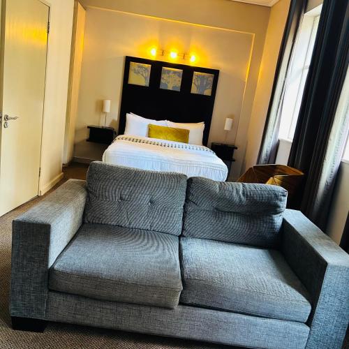 a living room with a couch and a bed at Native Suites 411 in Johannesburg