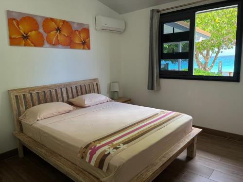a bedroom with a large bed with a window at Faré Pépénai in Avatoru
