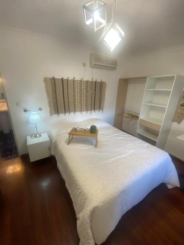 a bedroom with a white bed with a table on it at Pinzalez 