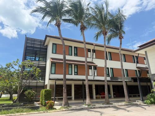 an office building with palm trees in front of it at Fisherman's Resort Haad Chao Samran in Haad Chao Samran