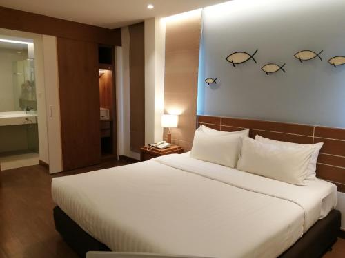 a bedroom with a large white bed with glasses on the wall at Fisherman's Resort Haad Chao Samran in Haad Chao Samran