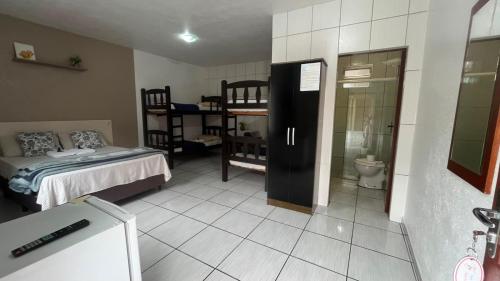 a room with a bedroom with a bed and a bathroom at Pousada Anjo Gabriel in Penha